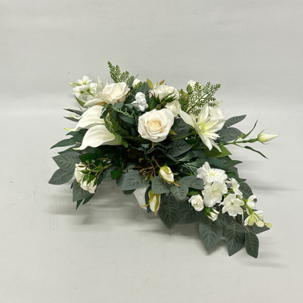 Kompozycja kwiatowa w odcieniach bieli z kalli, kremowych róż, z dodatkiem małego aniołka
