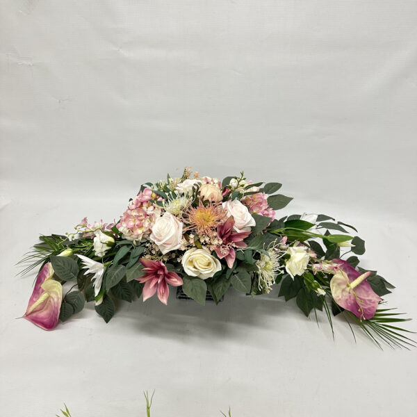 Kompozycja kwiatowa w odcieniach różu wykonana z clematis, gumowanego anturium, róż i hortensji